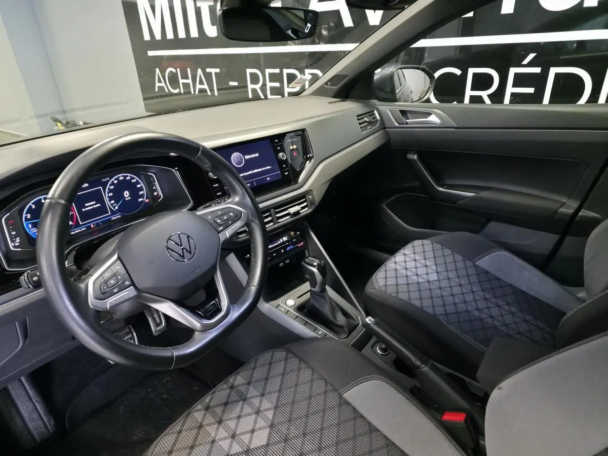 Intérieur avant du Volkswagen Taigo gris foncé, vue côté conducteur avec volant multifonctions et tableau de bord digital.