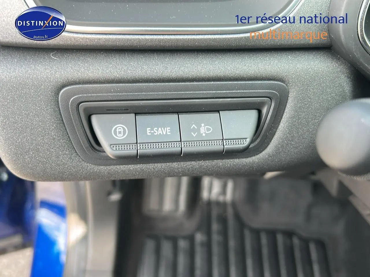 Gros plan sur les commandes sous le tableau de bord du Renault Captur bleu iron, boutons E-SAVE et réglage des phares.