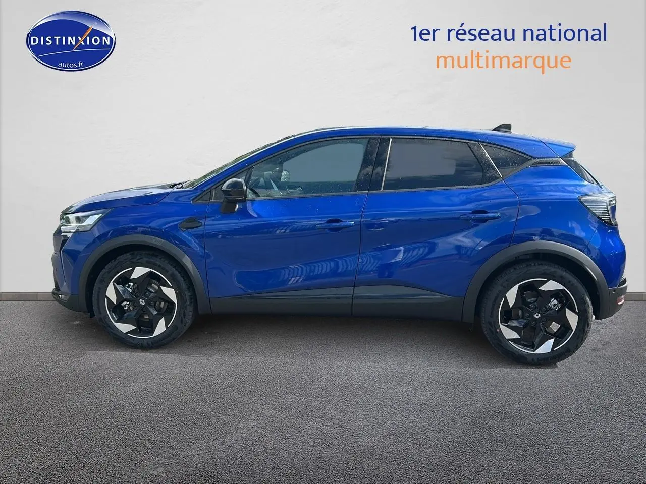 Profil droit d’un Renault Captur 1.6 e-tech hybride 145 techno bleu iron avec jantes alu et vitres surteintées.