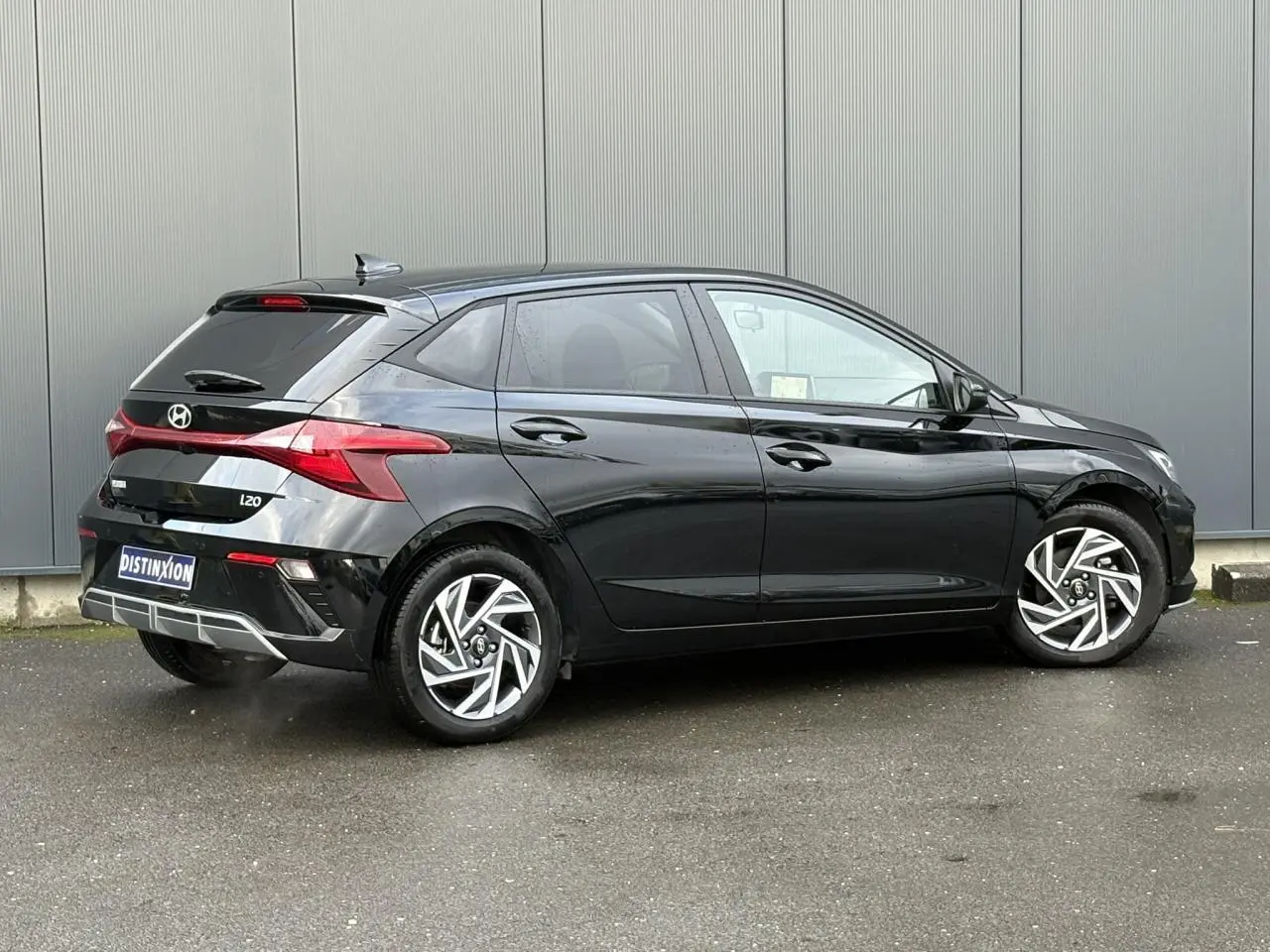 Vue 3/4 arrière droite d'une Hyundai i20 noire Phantom Metal avec jantes alliage diamantées et vitres surteintées.