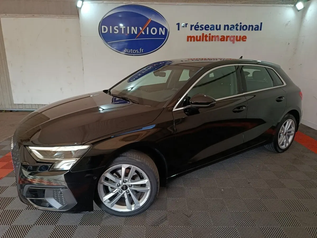 Audi A3 35 TDI noir vue 3/4 avant droit en intérieur, avec jantes alliage et phares LED allumés.