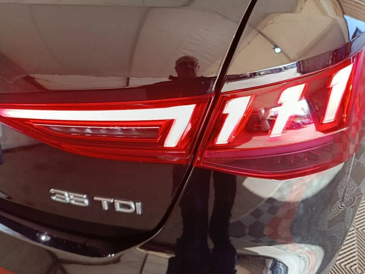 Gros plan sur le feu arrière droit et le logo 35 TDI d'une Audi A3 noire, version diesel.