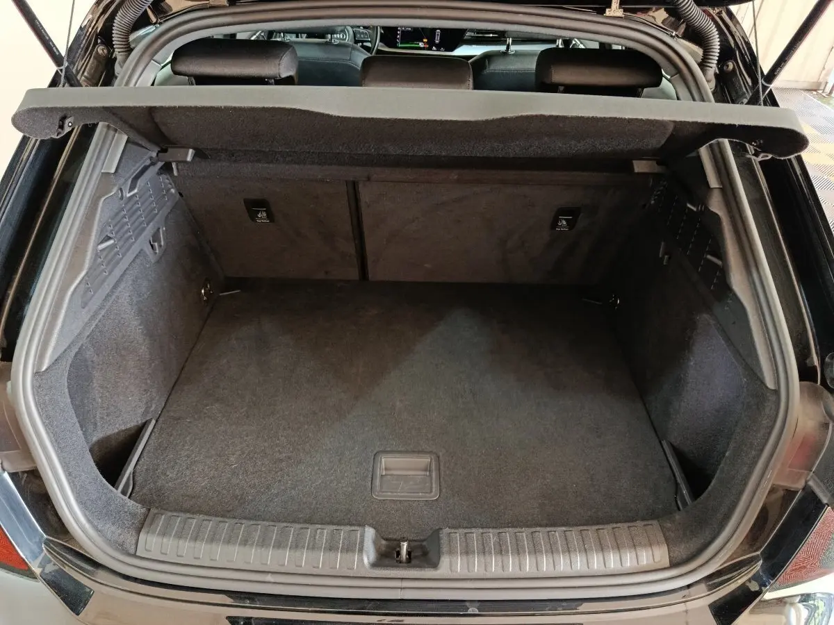 Vue arrière du coffre ouvert d'une Audi A3 35 TDI noire, montrant un espace de rangement propre et spacieux.