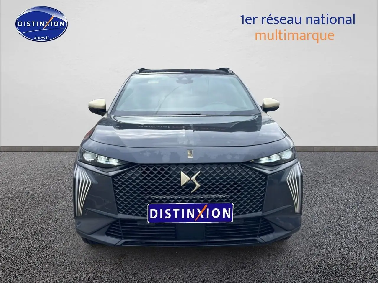 Vue frontale d'un DS7 gris titane avec calandre distinctive et feux LED verticaux marquants.