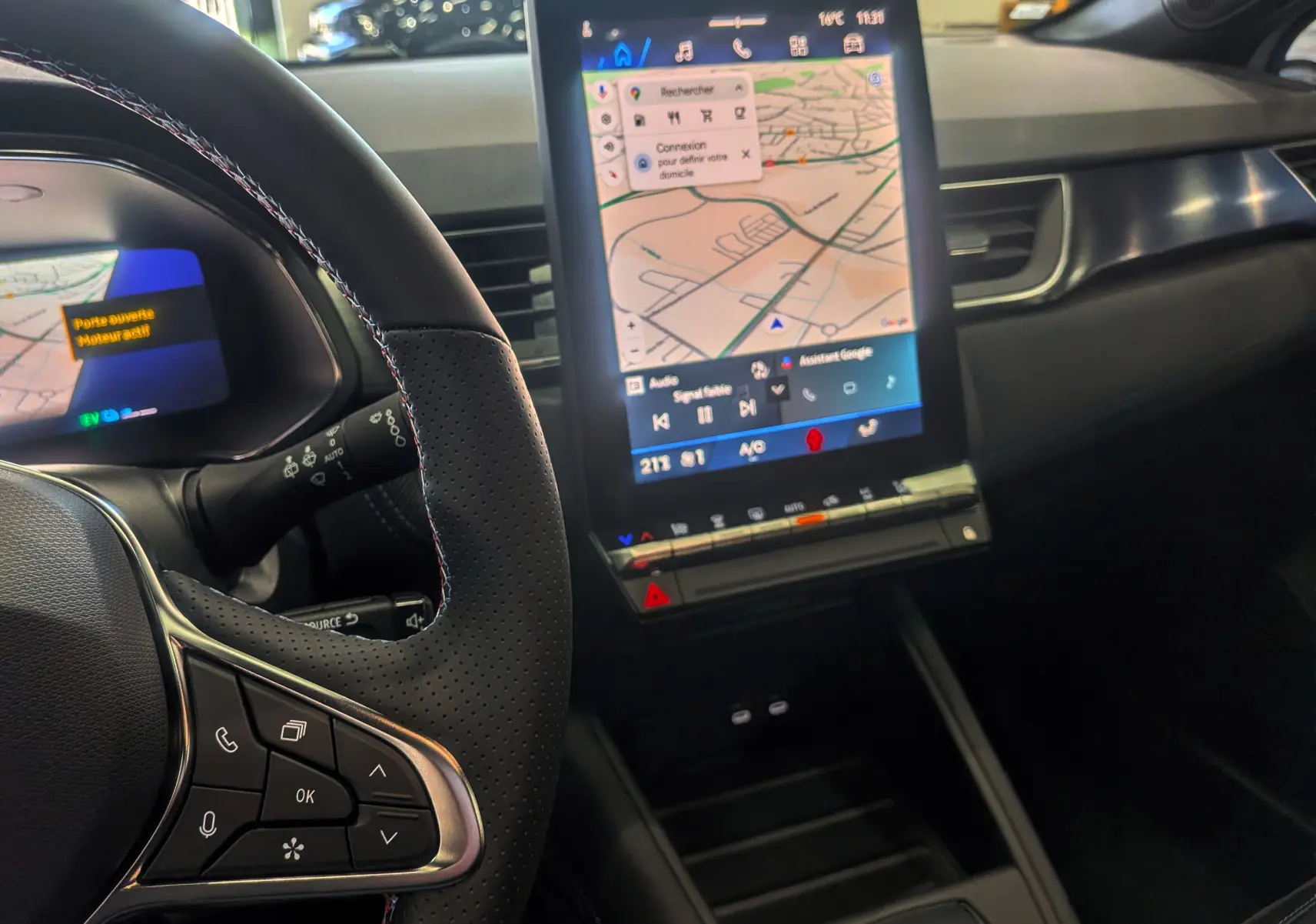 Vue intérieure centrée sur le volant et l'écran tactile vertical du tableau de bord du Renault Symbioz blanc nacré.