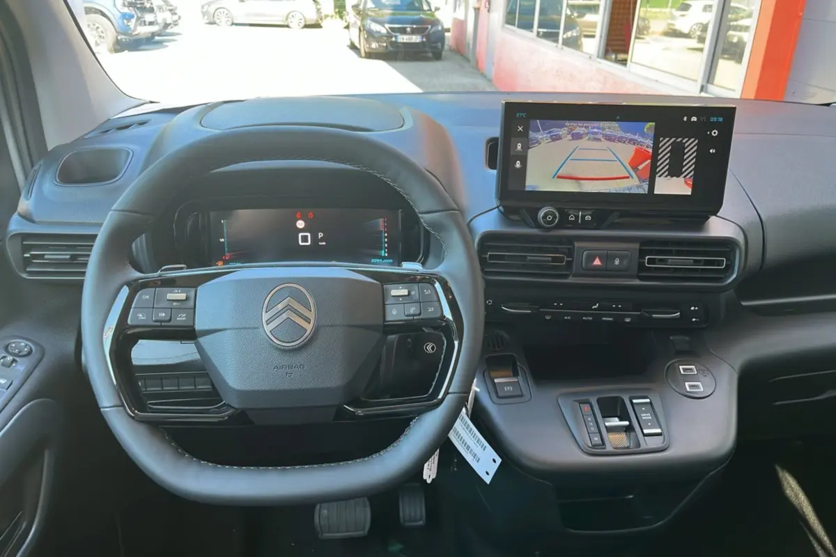 Vue intérieure du tableau de bord du Citroën Berlingo 2025, volant cuir multifonctions et écran tactile caméra de recul.