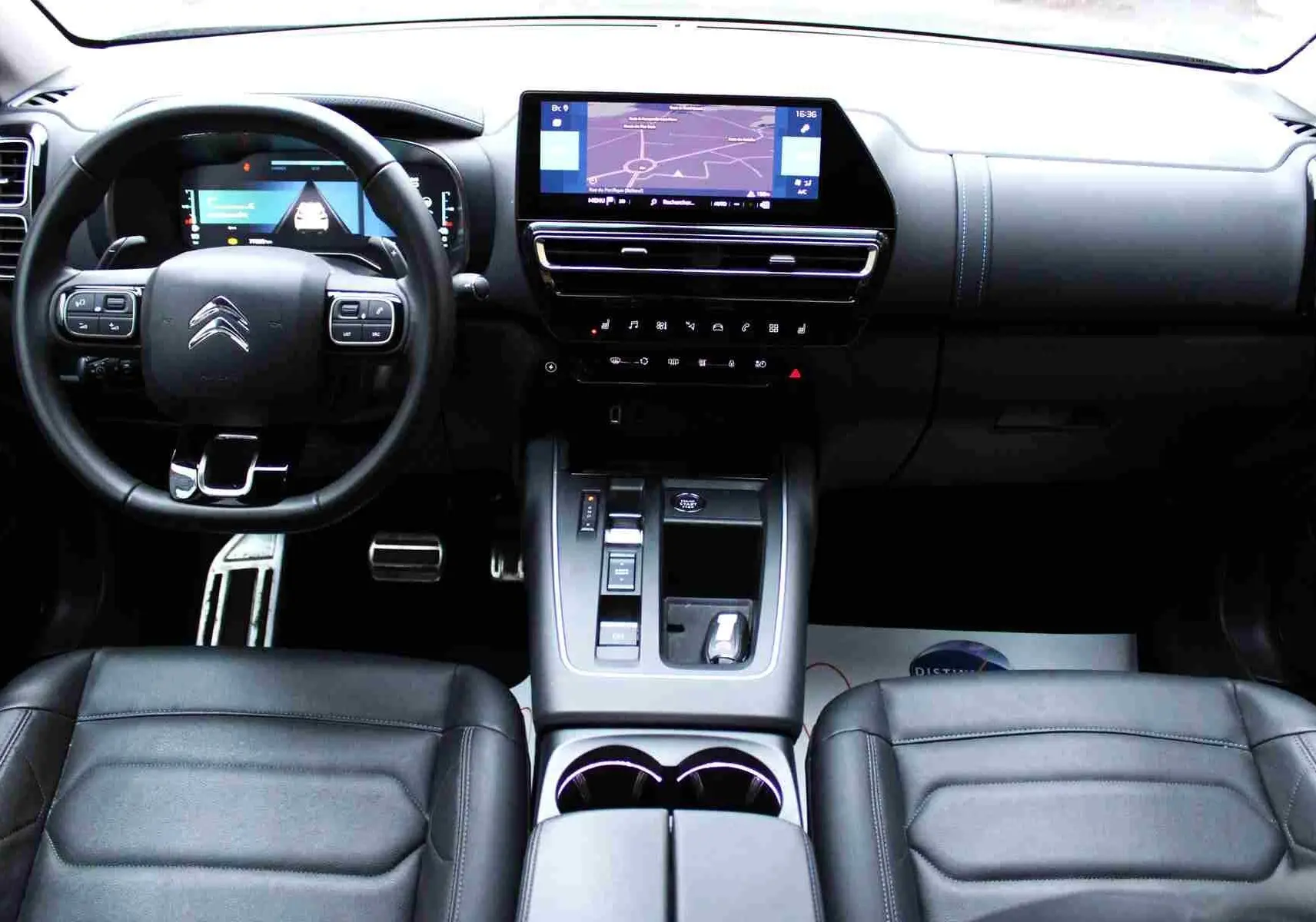 Vue intérieure avant du Citroën C5 Aircross hybride, montrant tableau de bord, volant cuir et écran tactile central.