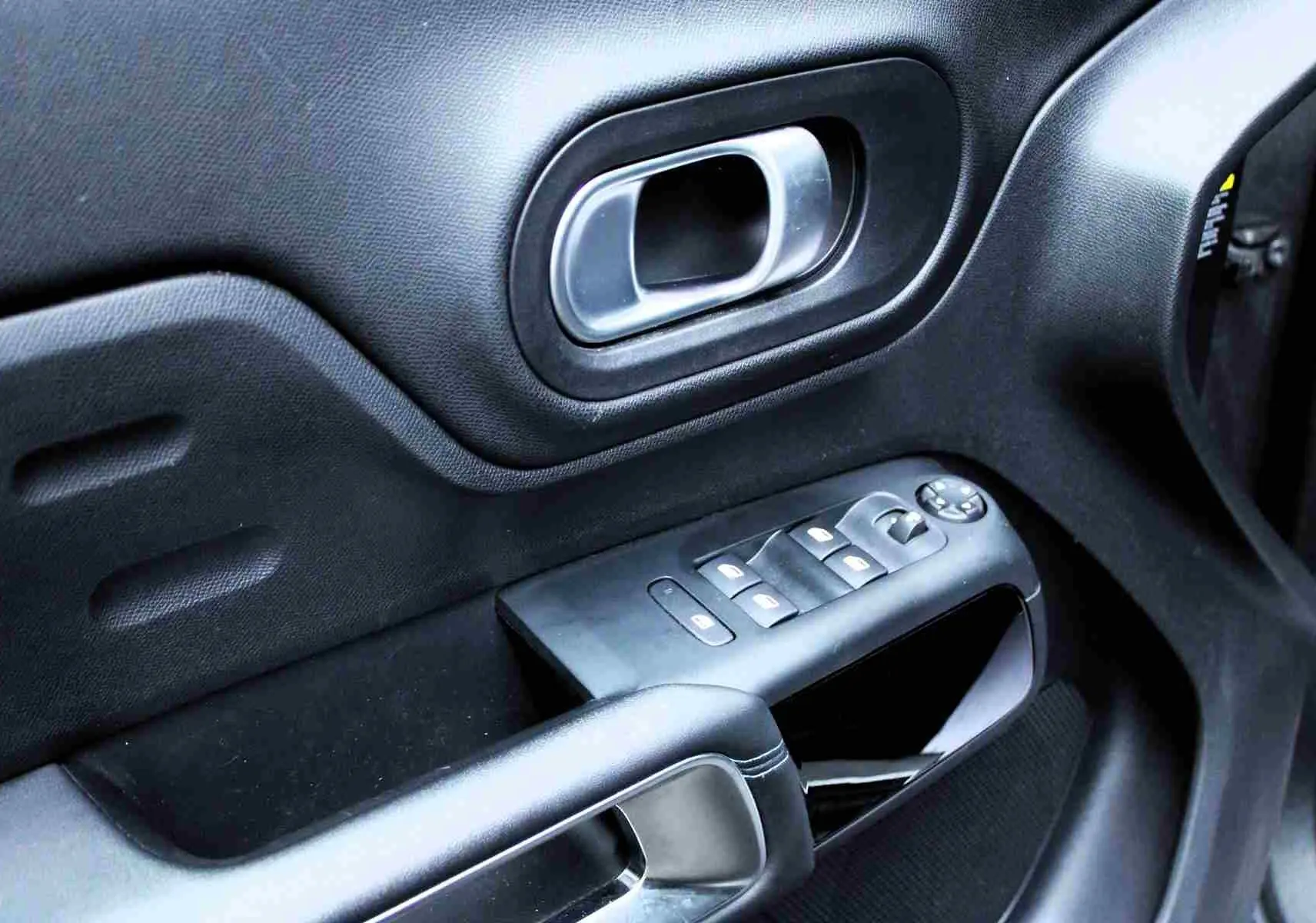 Gros plan sur la porte côté conducteur du Citroën C5 Aircross gris platinium, montrant la poignée et les commandes de vitres.