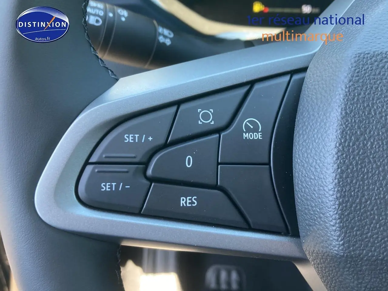 Gros plan sur les commandes multifonctions à gauche du volant du Dacia Duster noir, version 2025.