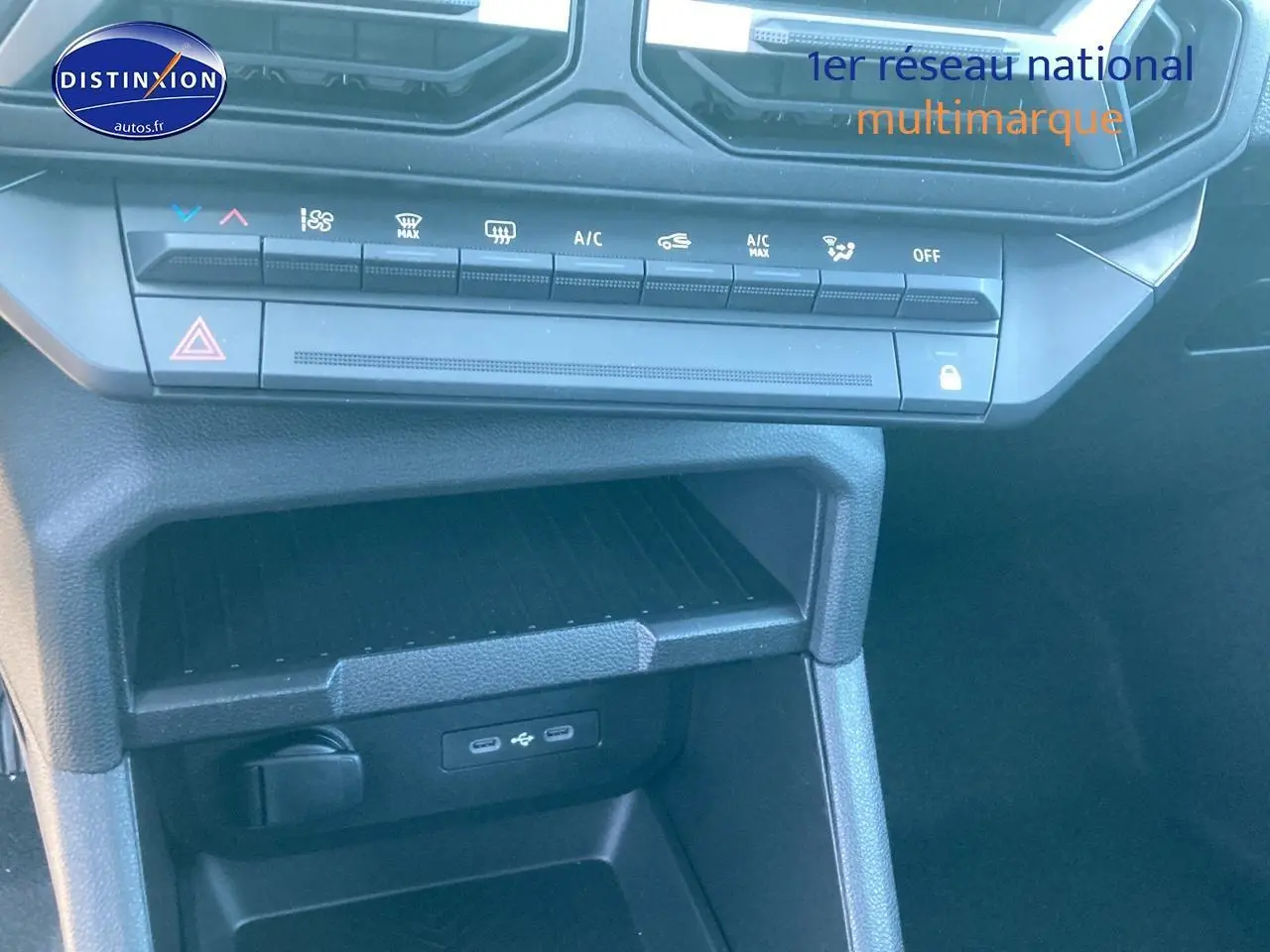 Vue rapprochée de la console centrale noire du Dacia Duster 2025 avec commandes climatisation et ports USB visibles.