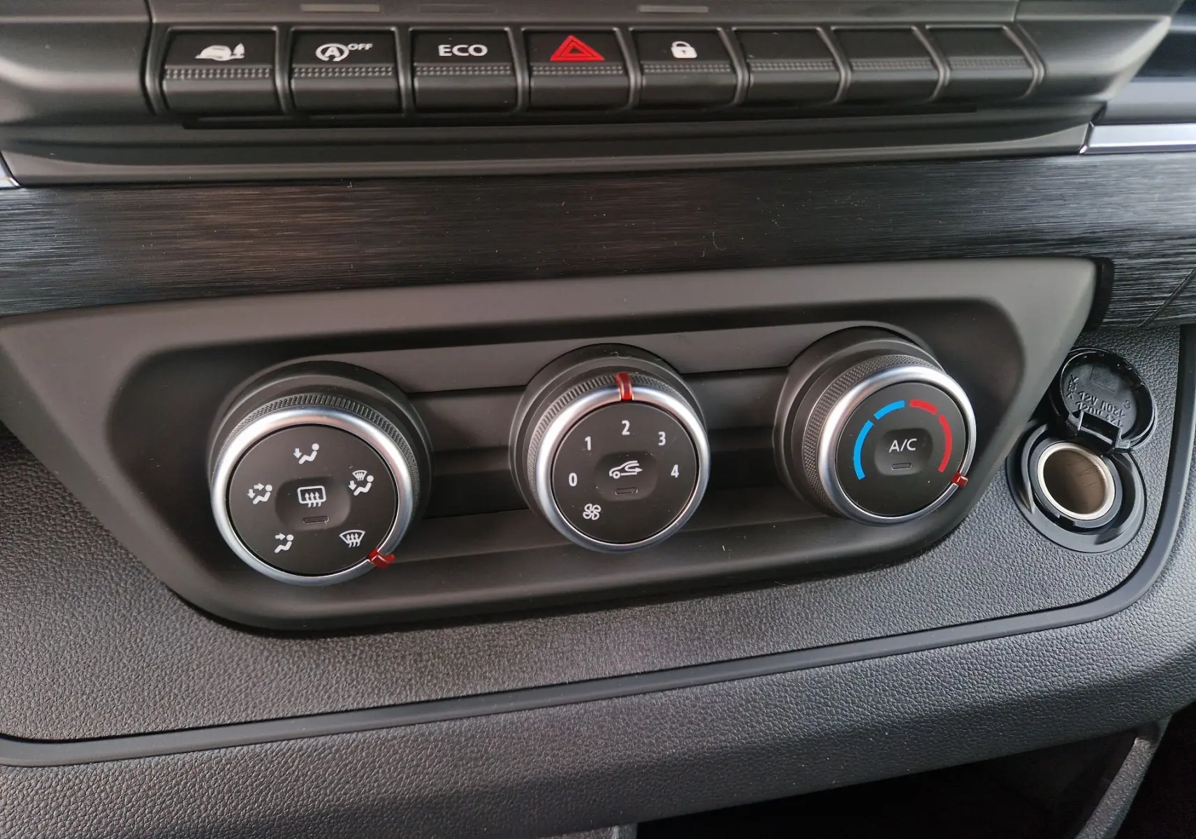 Gros plan sur les commandes de climatisation et ventilation du tableau de bord du Nissan Primastar gris urbain 2025.