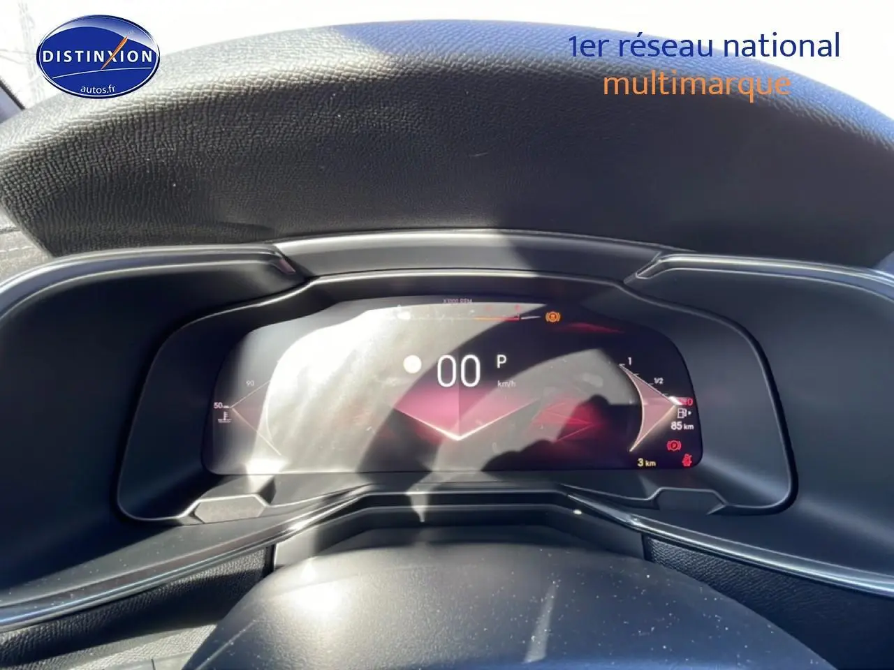 Vue rapprochée du tableau de bord numérique du DS7 bleu, affichant la vitesse à 0 km/h et l'indicateur de carburant.