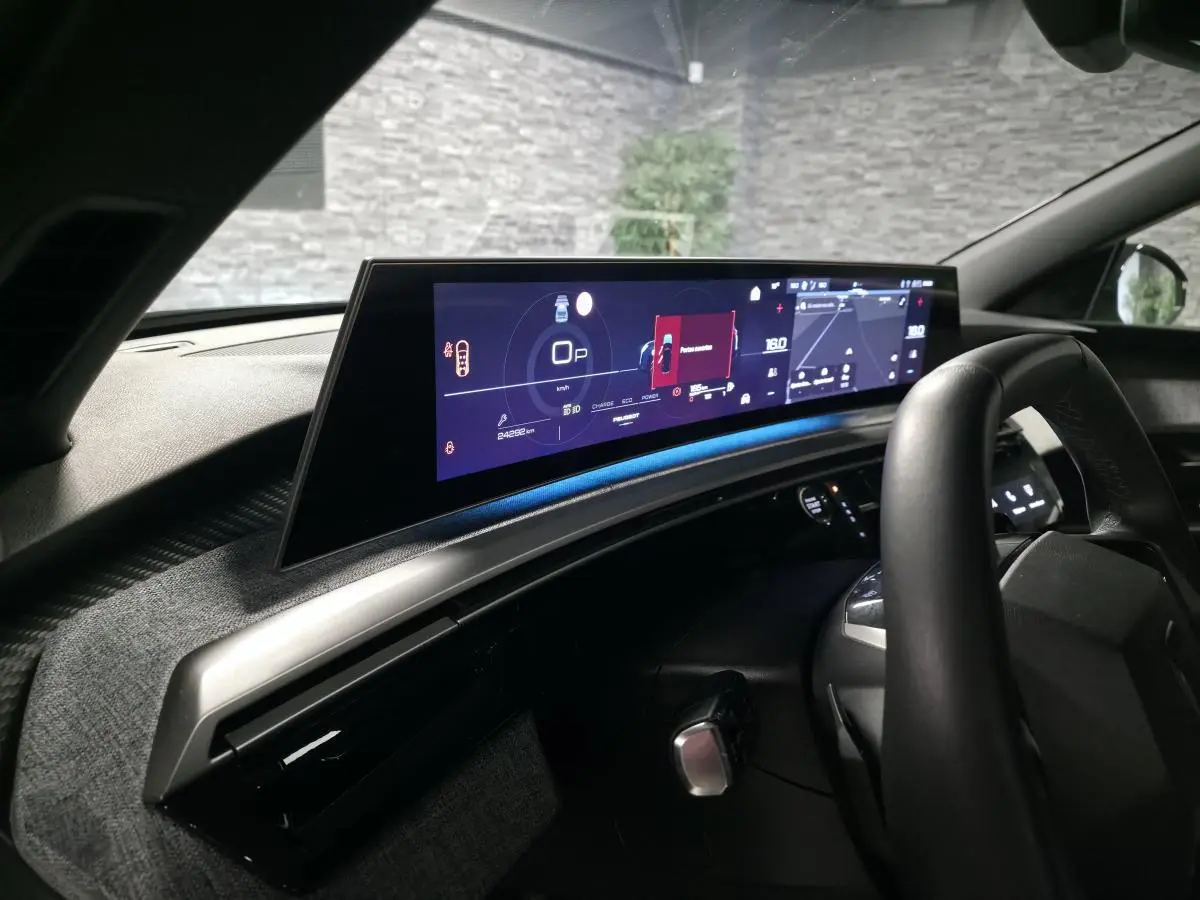 Vue intérieure du tableau de bord du Peugeot 5008 noir 2025, avec écran panoramique HD et volant compact noir laqué.