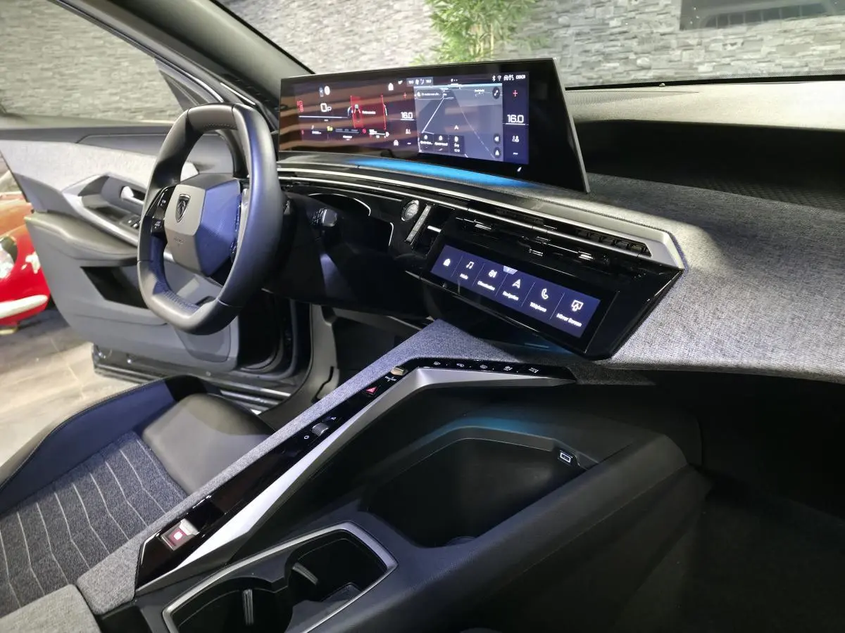 Vue intérieure côté conducteur du Peugeot 5008 2025 noir, avec tableau de bord numérique panoramique et console centrale moderne.