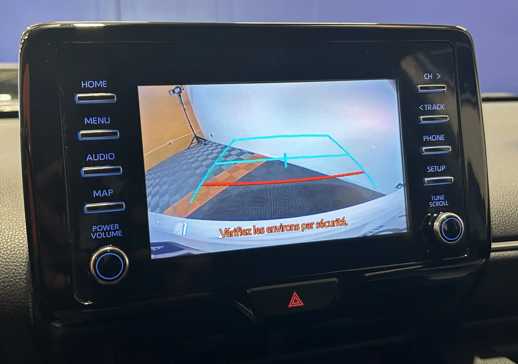 Écran central de la Toyota Yaris hybride 2021 montrant la caméra de recul avec lignes de guidage colorées.