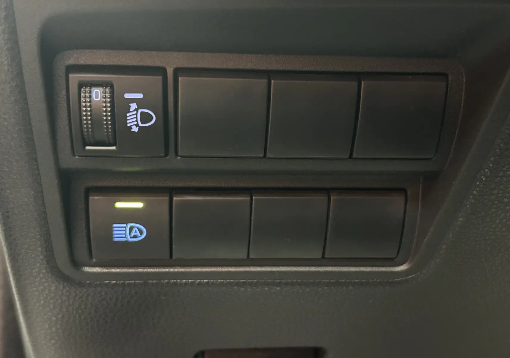 Gros plan sur les commandes d’éclairage du tableau de bord d’une Toyota Yaris blanche hybride 2021.