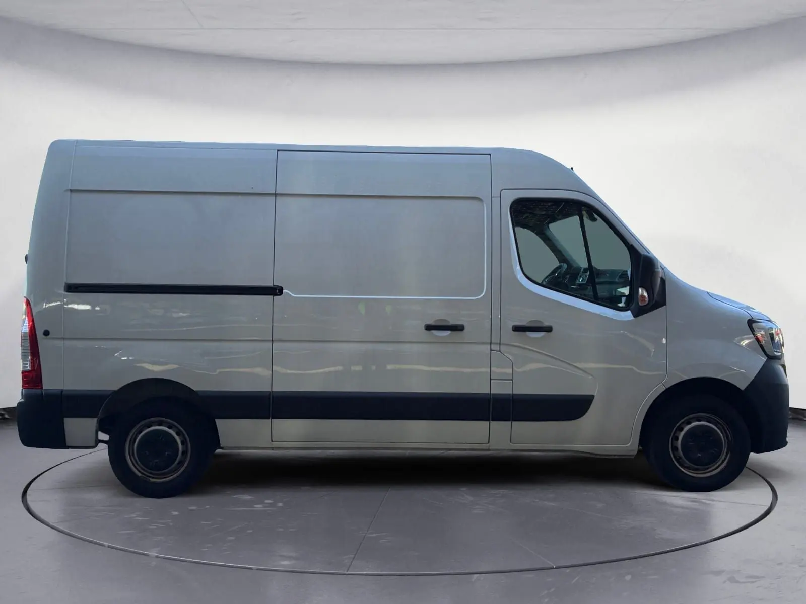 Profil droit d’un utilitaire blanc Renault Master L2H2 2024 avec porte coulissante et protections noires sur les bas de caisse.