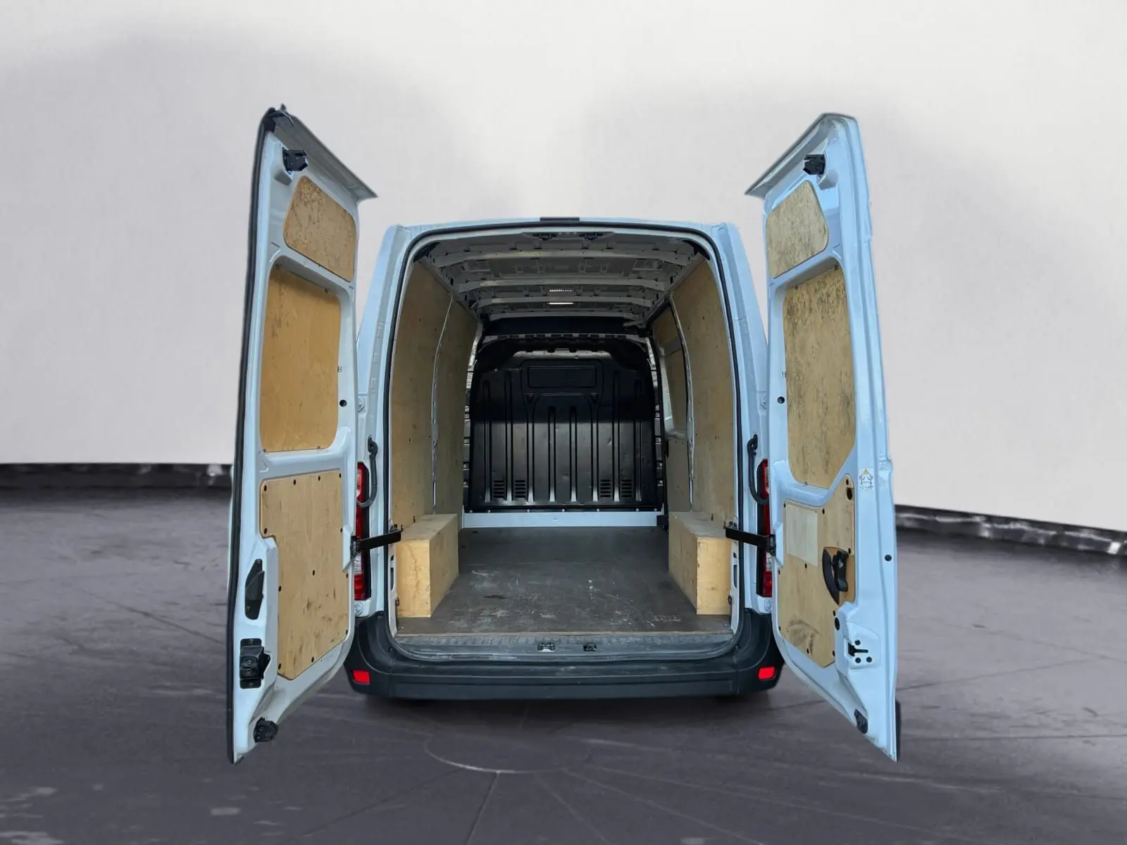 Vue arrière du Renault Master blanc 2024 avec portes ouvertes révélant l'espace de chargement doublé en bois.