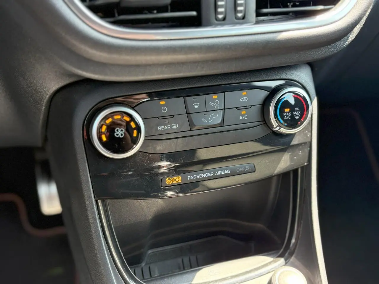 Vue rapprochée de la console centrale noire du Ford Puma ST Line 2020, avec commandes climatisation et témoin airbag passager.