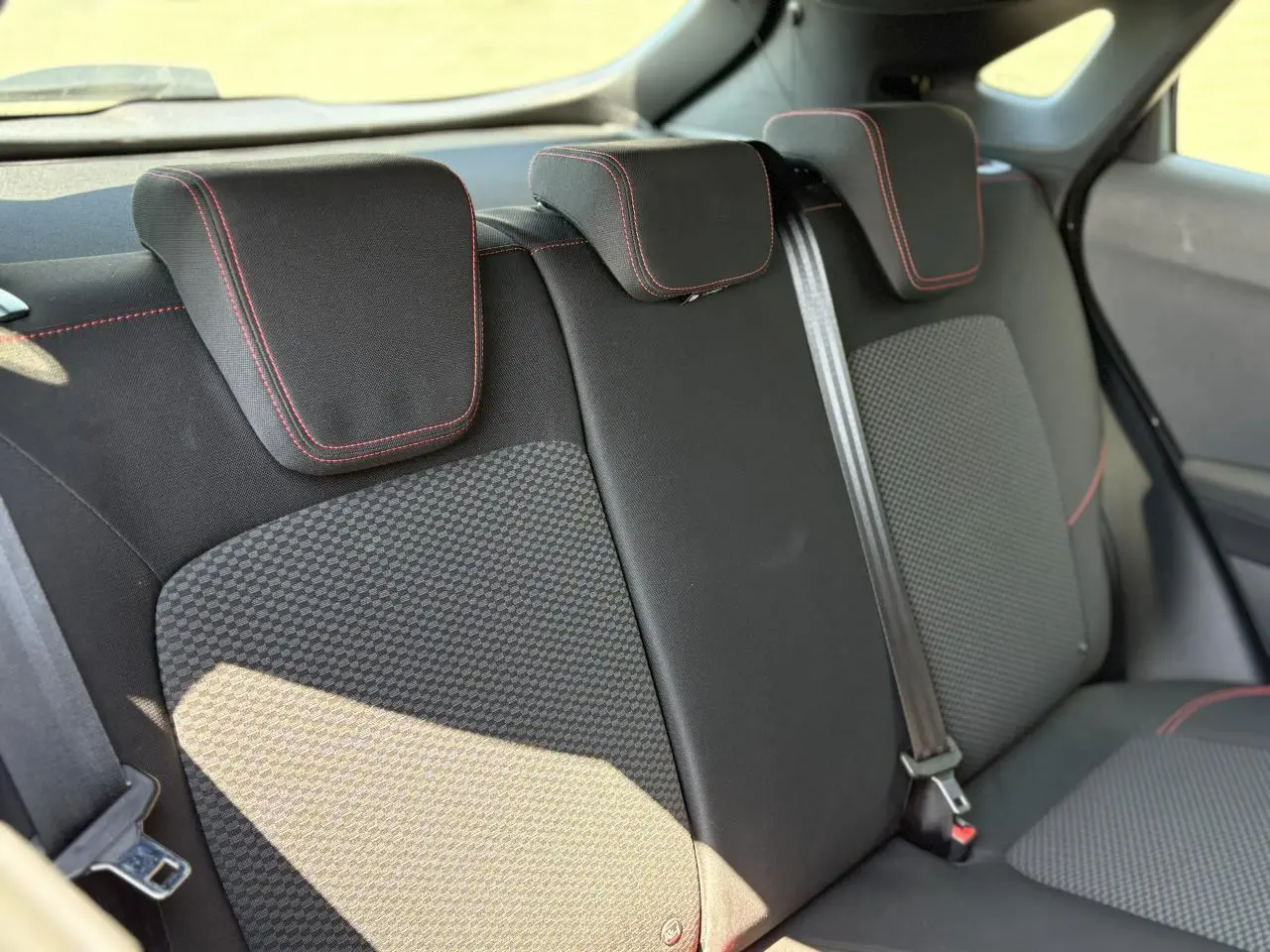 Vue rapprochée des sièges arrière noirs avec surpiqûres rouges du Ford Puma ST Line 2020, finition tissu.