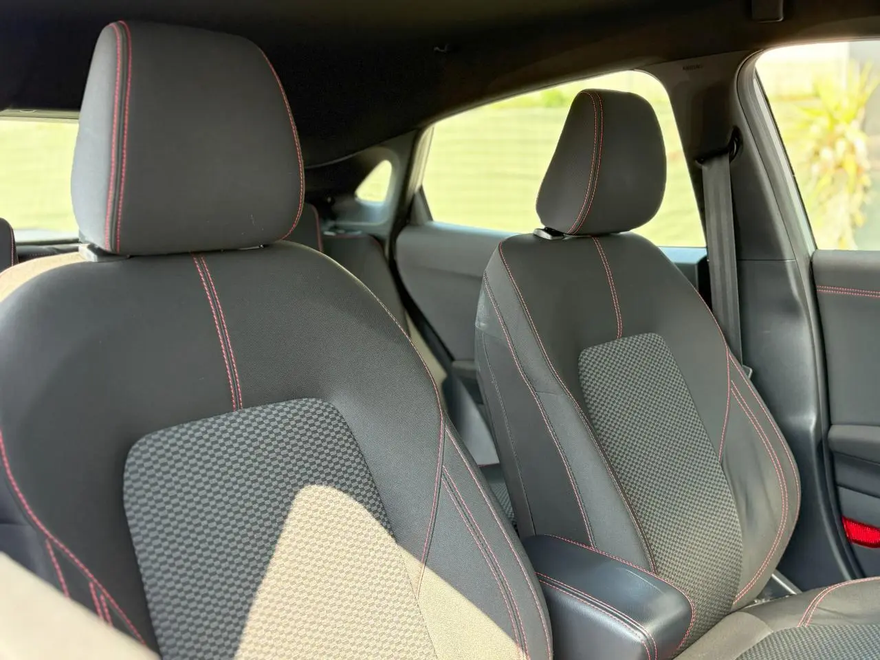 Gros plan sur les sièges avant en tissu noir avec surpiqûres rouges du Ford Puma Gris Solar 2020 finition ST Line.