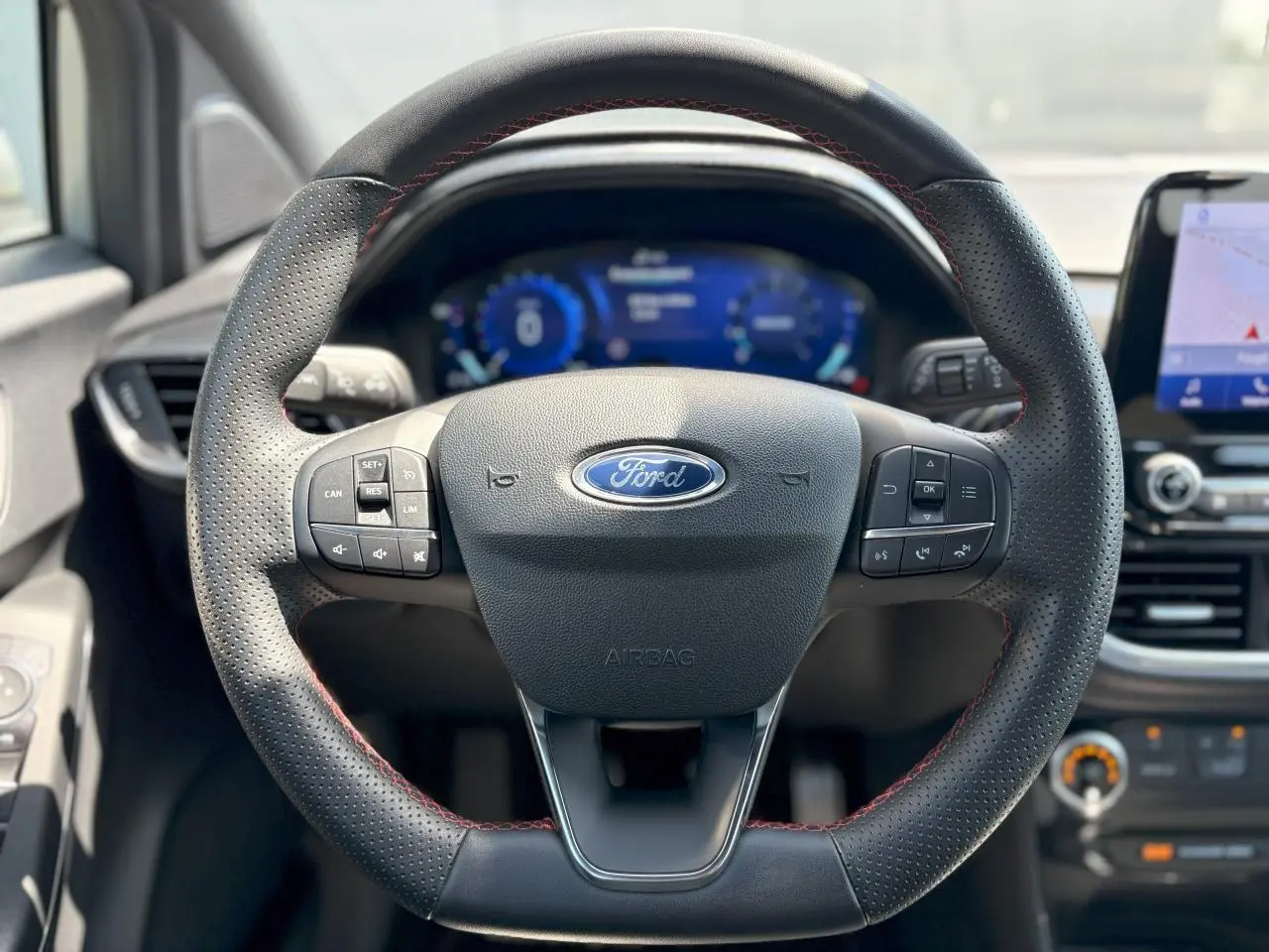 Volant en cuir noir à surpiqûres rouges de la Ford Puma ST Line 2020 avec tableau de bord numérique et écran GPS tactile.