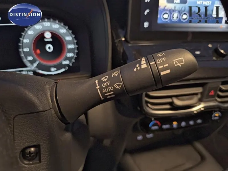 Gros plan sur la commande des essuie-glaces à gauche du volant dans l’habitacle du Nissan Juke gris perle métallisé 2025.