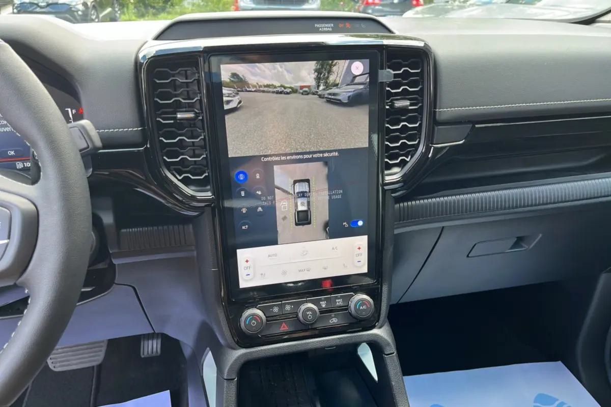 Vue intérieure centrée sur l’écran tactile vertical du Ford Ranger gris zen avec affichage caméra 360° et commandes climatisation.