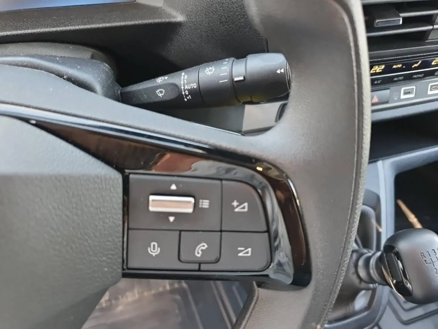 Gros plan sur les commandes audio au volant noir et levier de vitesse manuel dans l’habitacle du Toyota Proace Fourgon blanc Glacier.