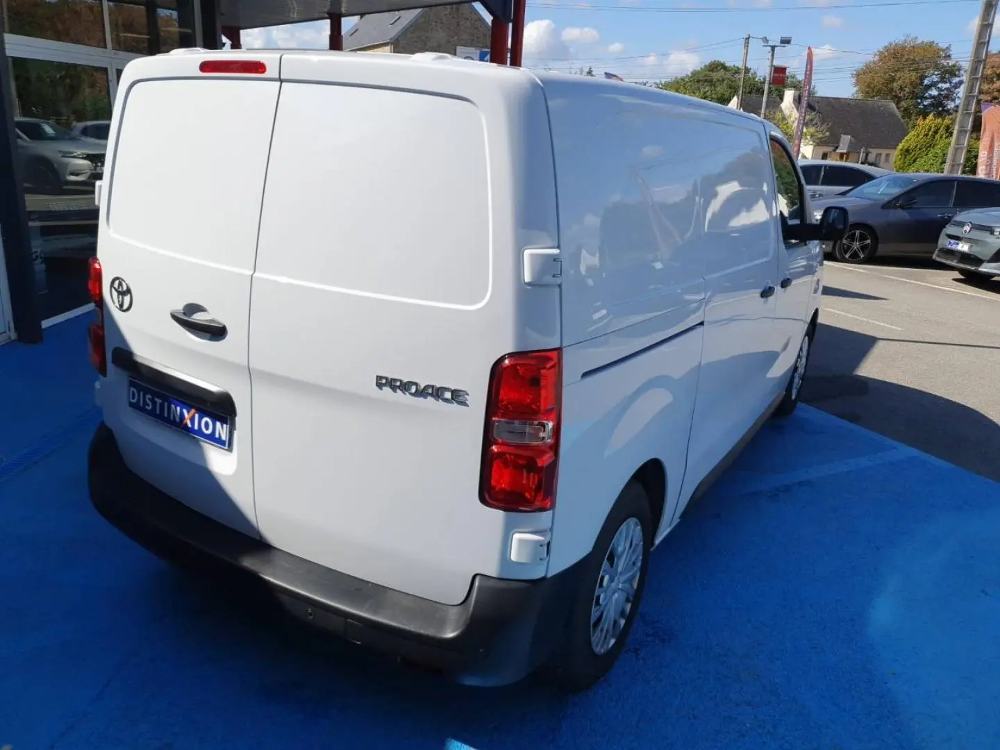 Toyota Proace Fourgon blanc glacier vu en 3/4 arrière droit sur un parking extérieur.
