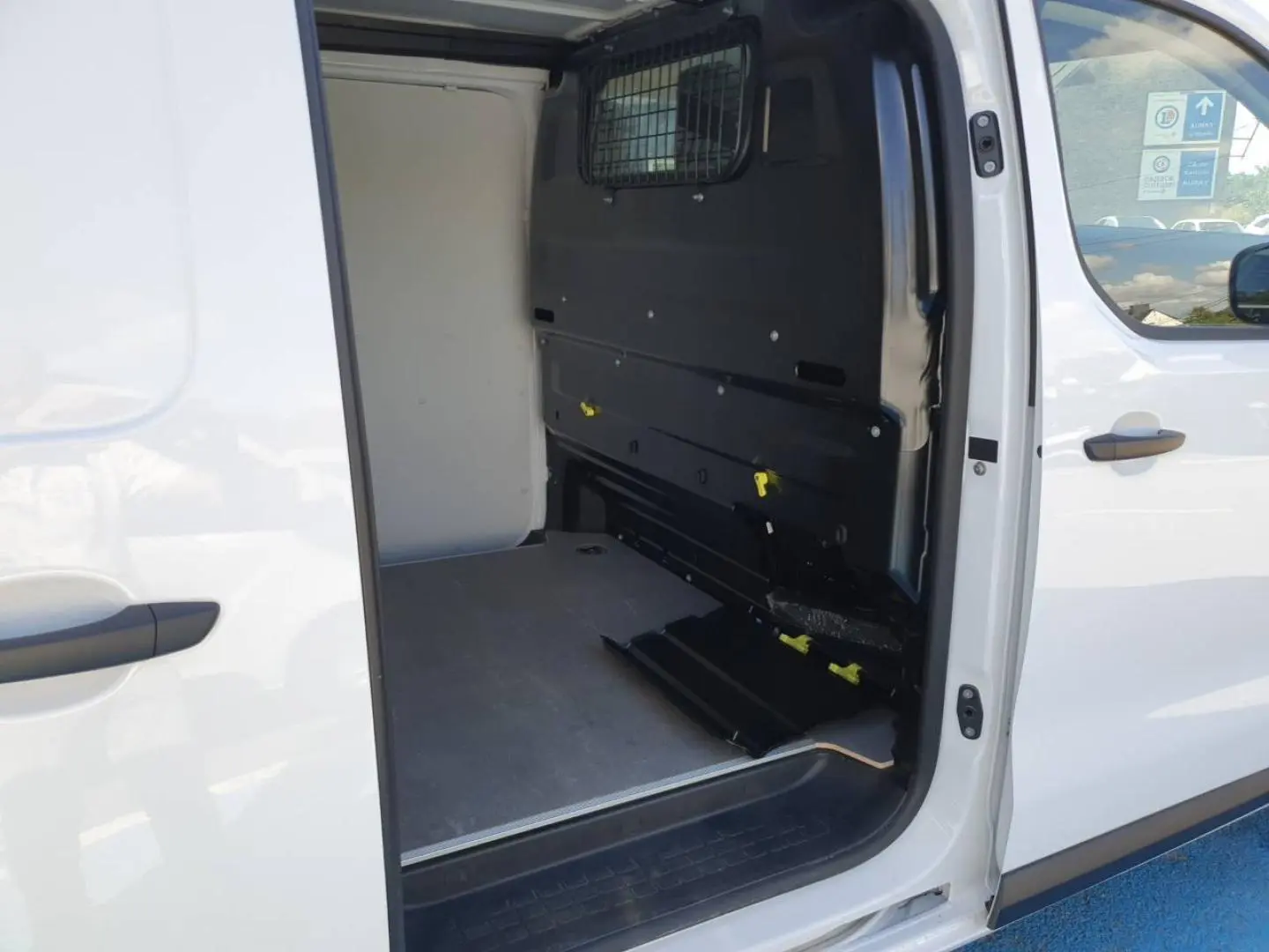 Vue latérale droite du Toyota Proace Fourgon blanc Glacier avec porte coulissante ouverte sur l’espace de chargement vide.