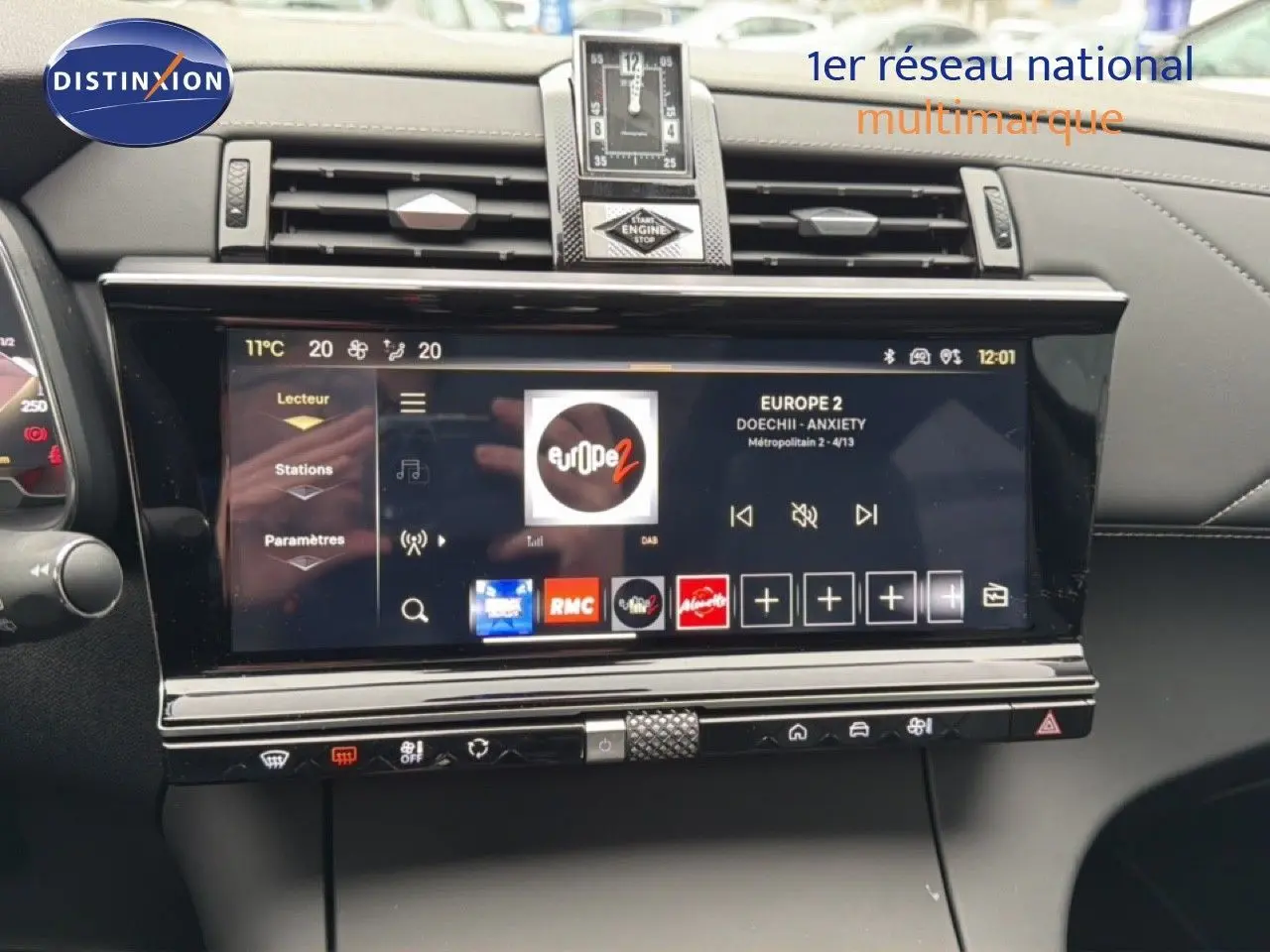 Tableau de bord du DS7 2024 gris titane, vue frontale sur l'écran tactile et horloge centrale élégante.