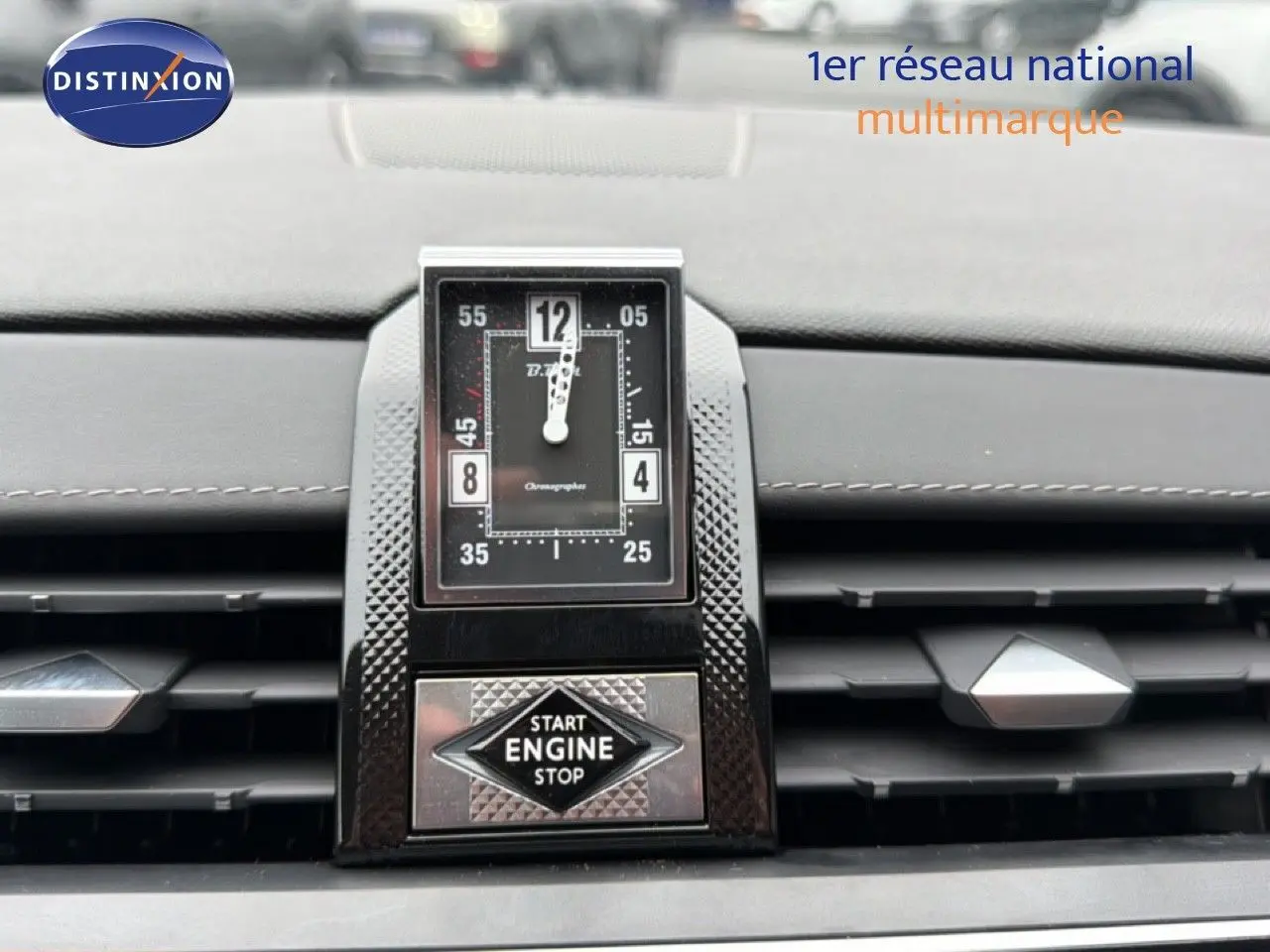 Gros plan sur l'horloge centrale et le bouton start/stop du tableau de bord du DS7 gris titane 2024.