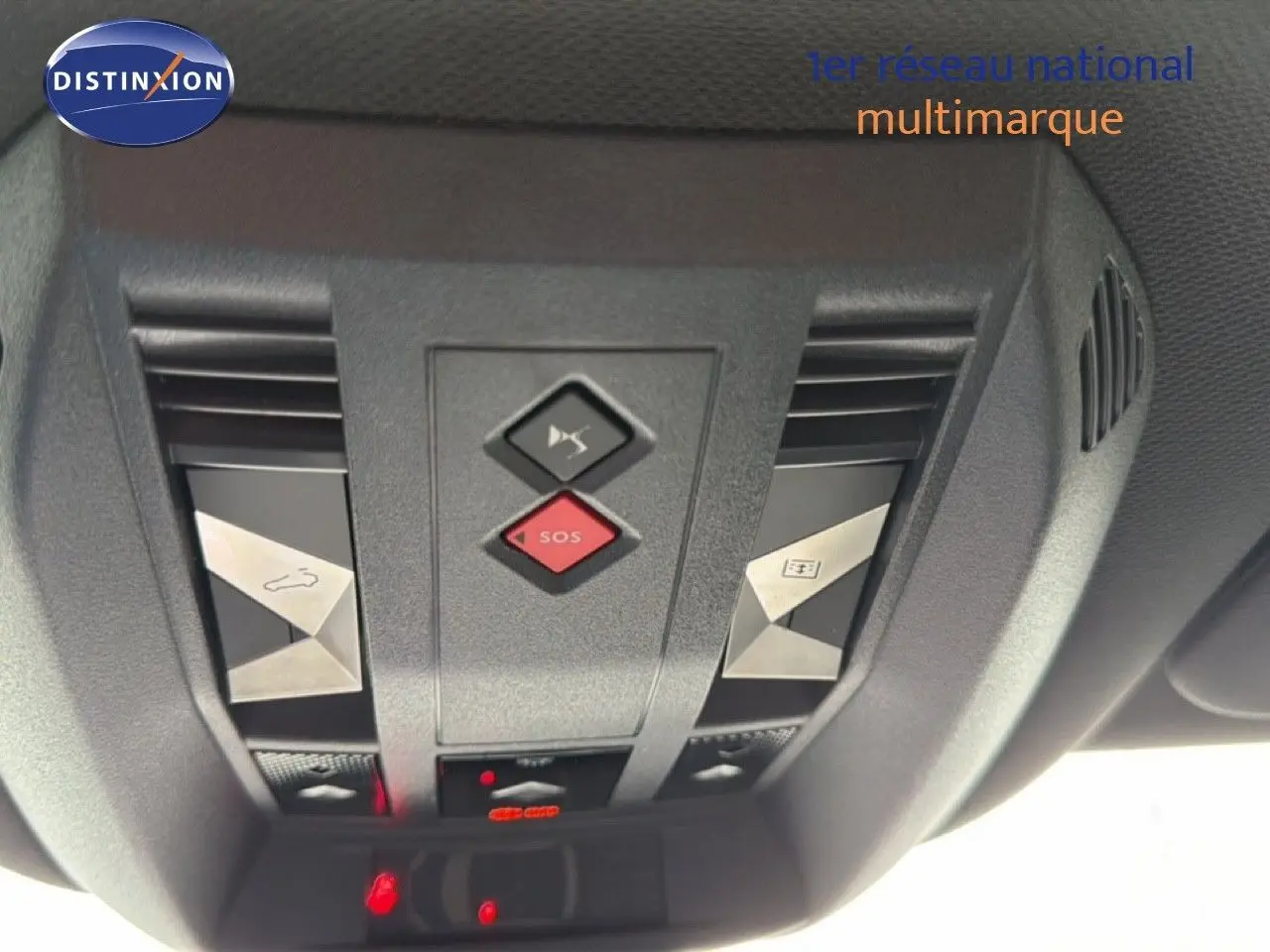 Vue en gros plan du panneau de commandes au plafond du DS7 gris titane, avec bouton SOS rouge et commandes d'ouverture toit ouvrant.