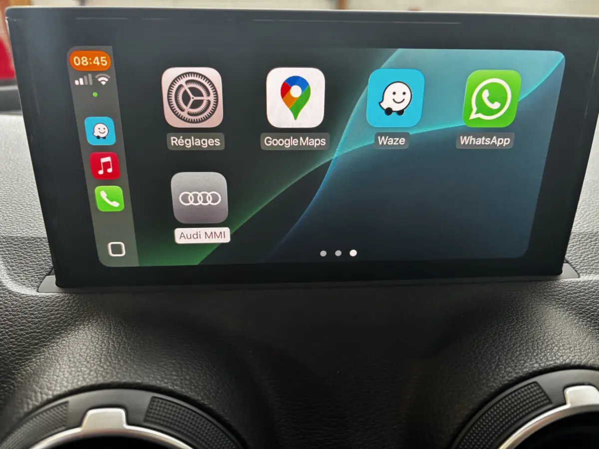 Écran central tactile de l'Audi Q2 35 TFSI S Line 2023 affichant les applications Google Maps, Waze et WhatsApp.