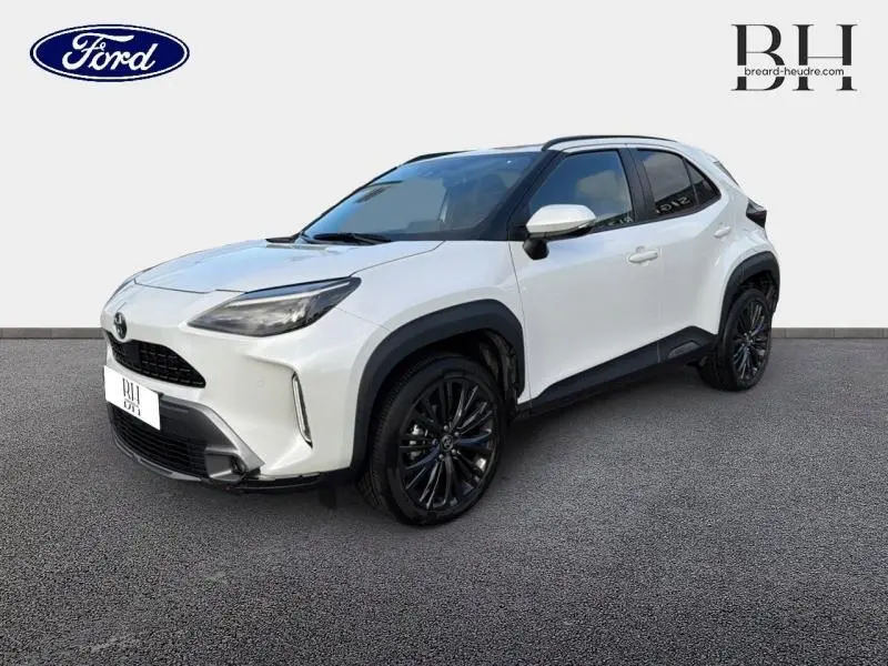 Toyota Yaris Cross blanc lunaire nacré vue 3/4 avant droit avec jantes noires et protections noires contrastées.