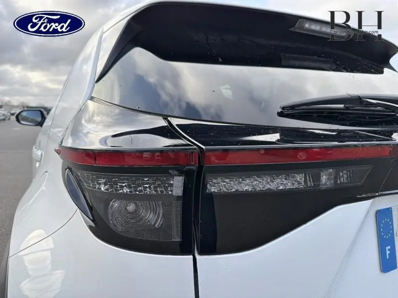 Gros plan sur le feu arrière droit du Toyota Yaris Cross blanc lunaire nacré, soulignant ses détails noirs et rouges.