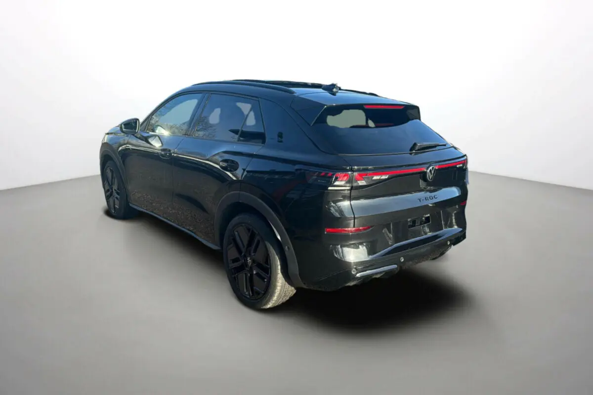 Volkswagen T-Roc noir ebène en 3/4 arrière droit, avec feux arrière LED et jantes noires distinctives.