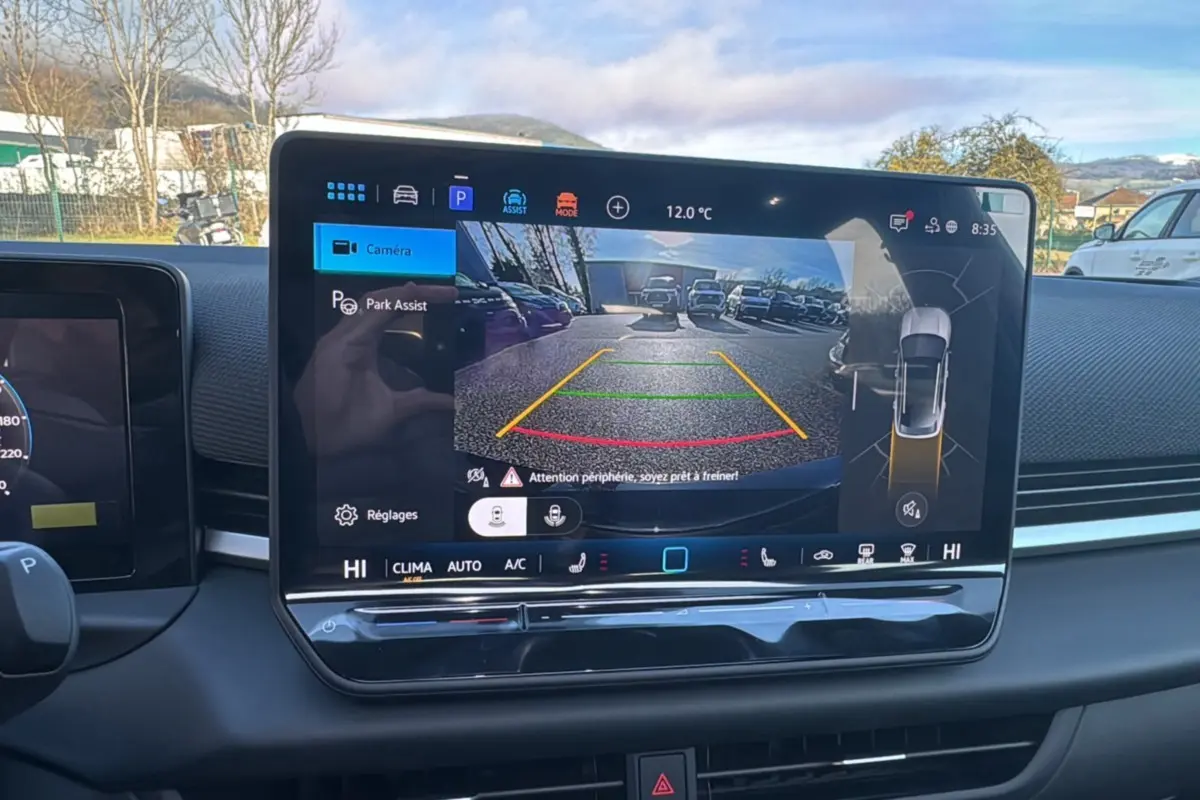 Écran central du Volkswagen T-Roc 2026 montrant la caméra de recul avec guidage de trajectoire en extérieur.