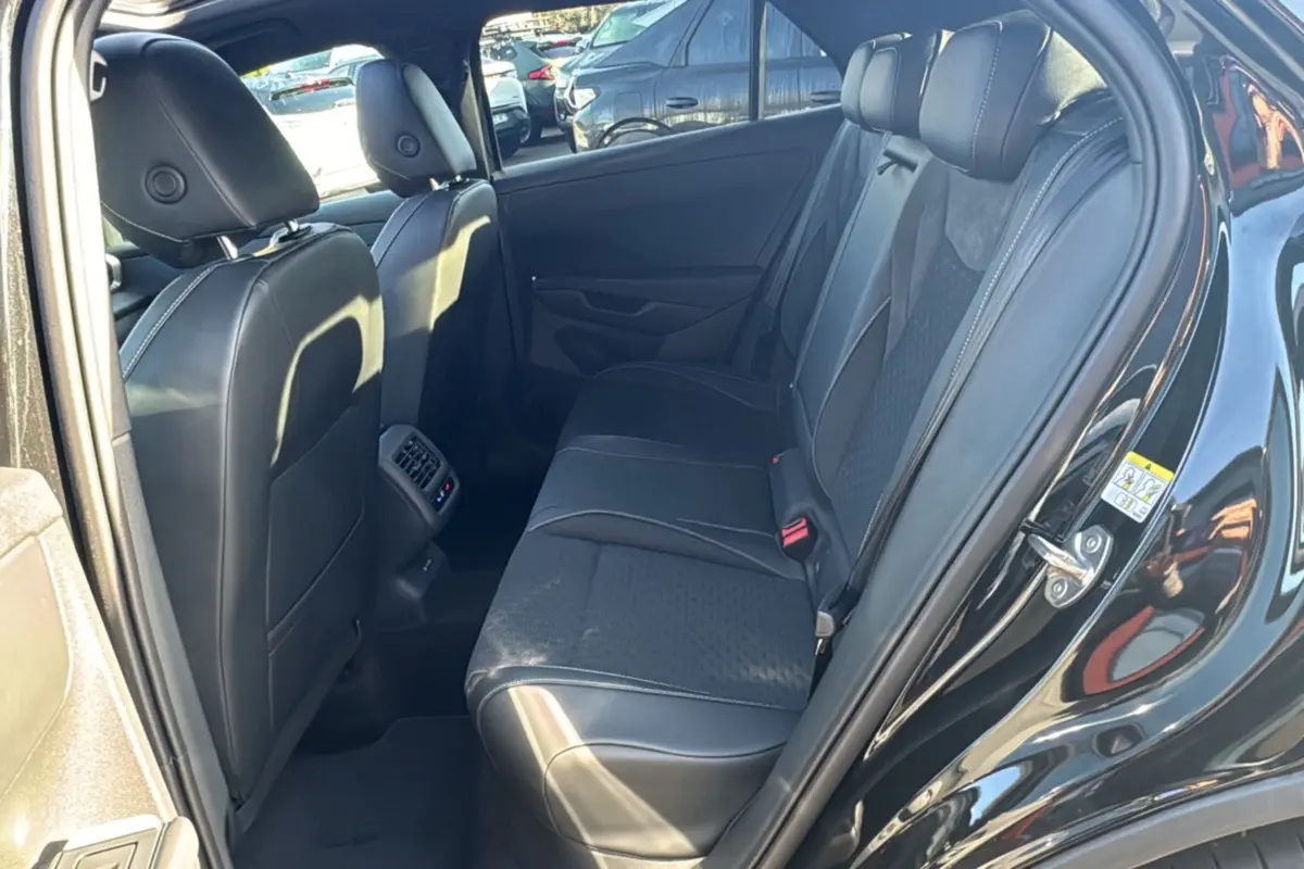 Vue intérieure arrière droite du Volkswagen T-Roc noir ébène, montrant la banquette en tissu et cuir avec appuie-têtes.