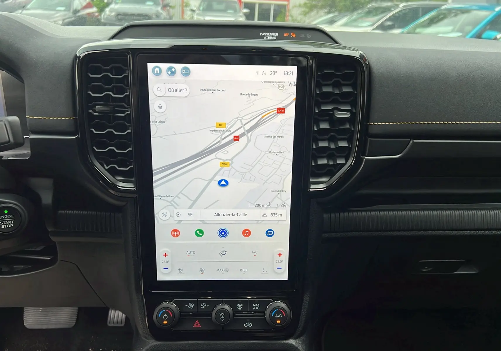 Vue intérieure centrée sur l’écran tactile vertical du Ford Ranger Wildtrak 2025, avec tableau de bord noir et détails en surpiqûres jaunes.