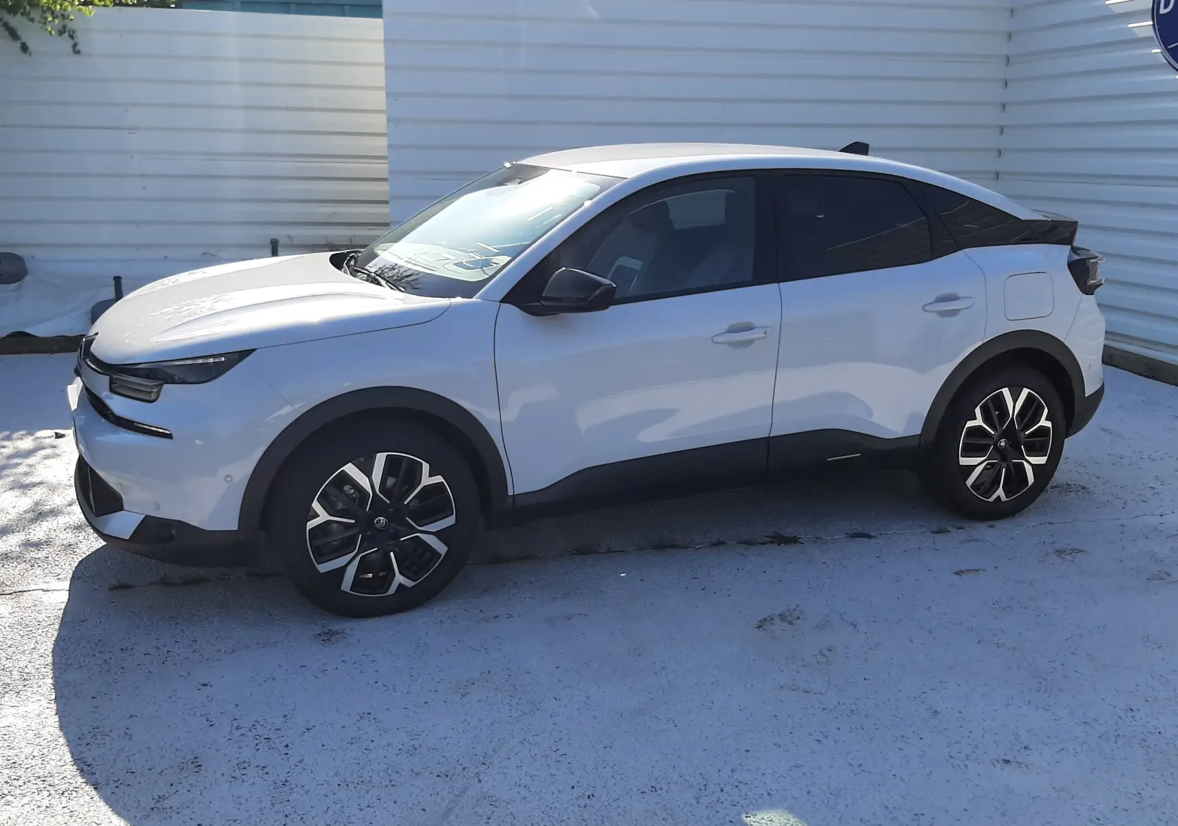 Vue de profil côté gauche d'une Citroën C4 blanche Okenite avec toit noir et jantes bi-ton 18 pouces.