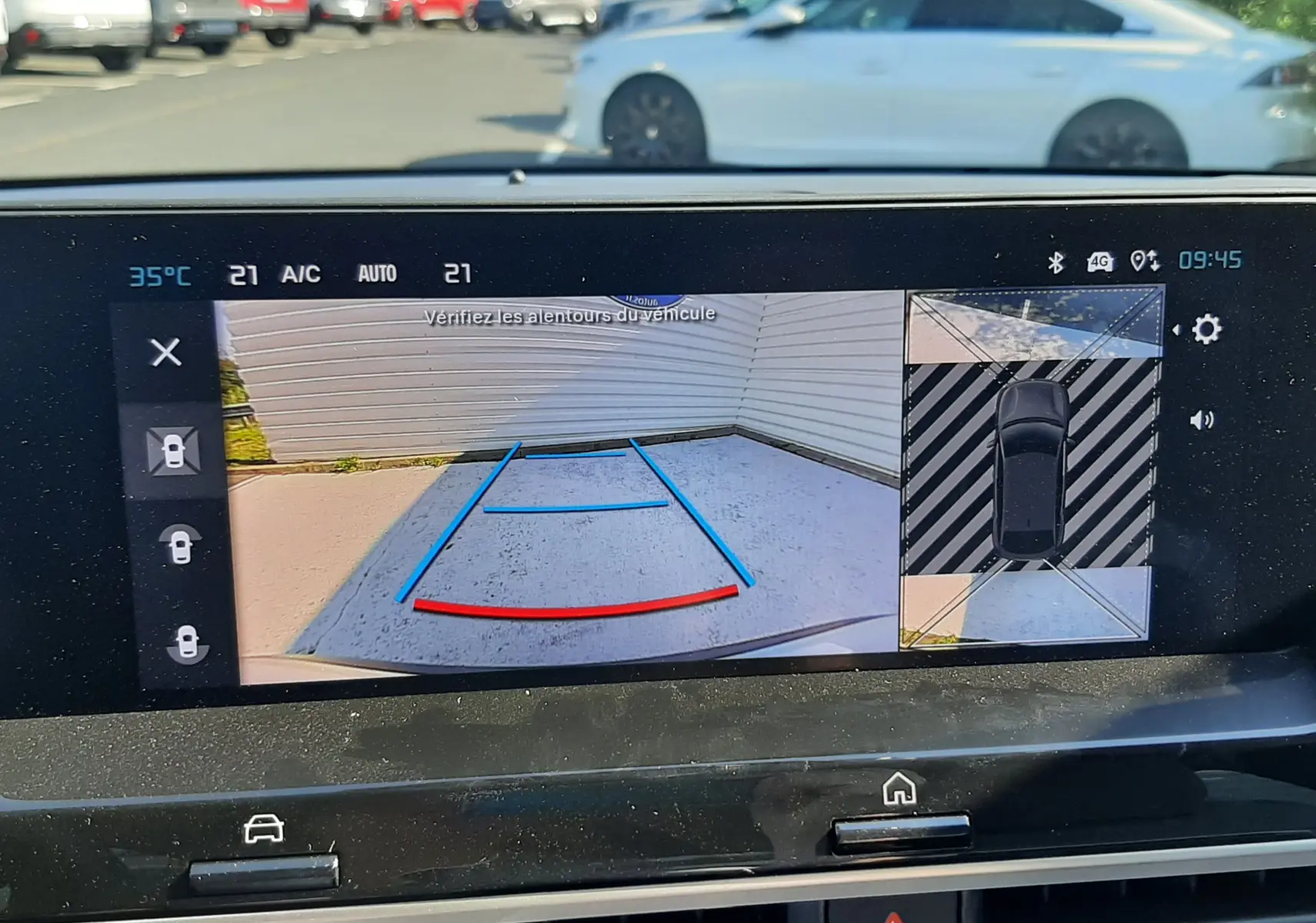 Écran intérieur de la Citroën C4 blanc Okenite montrant la caméra de recul avec vue arrière et angles morts.