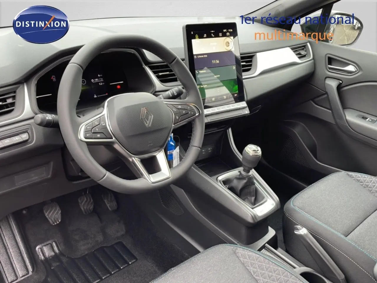 Intérieur avant du Renault Captur 2025 noir étoile métal, volant multifonction et écran tactile vertical au centre.