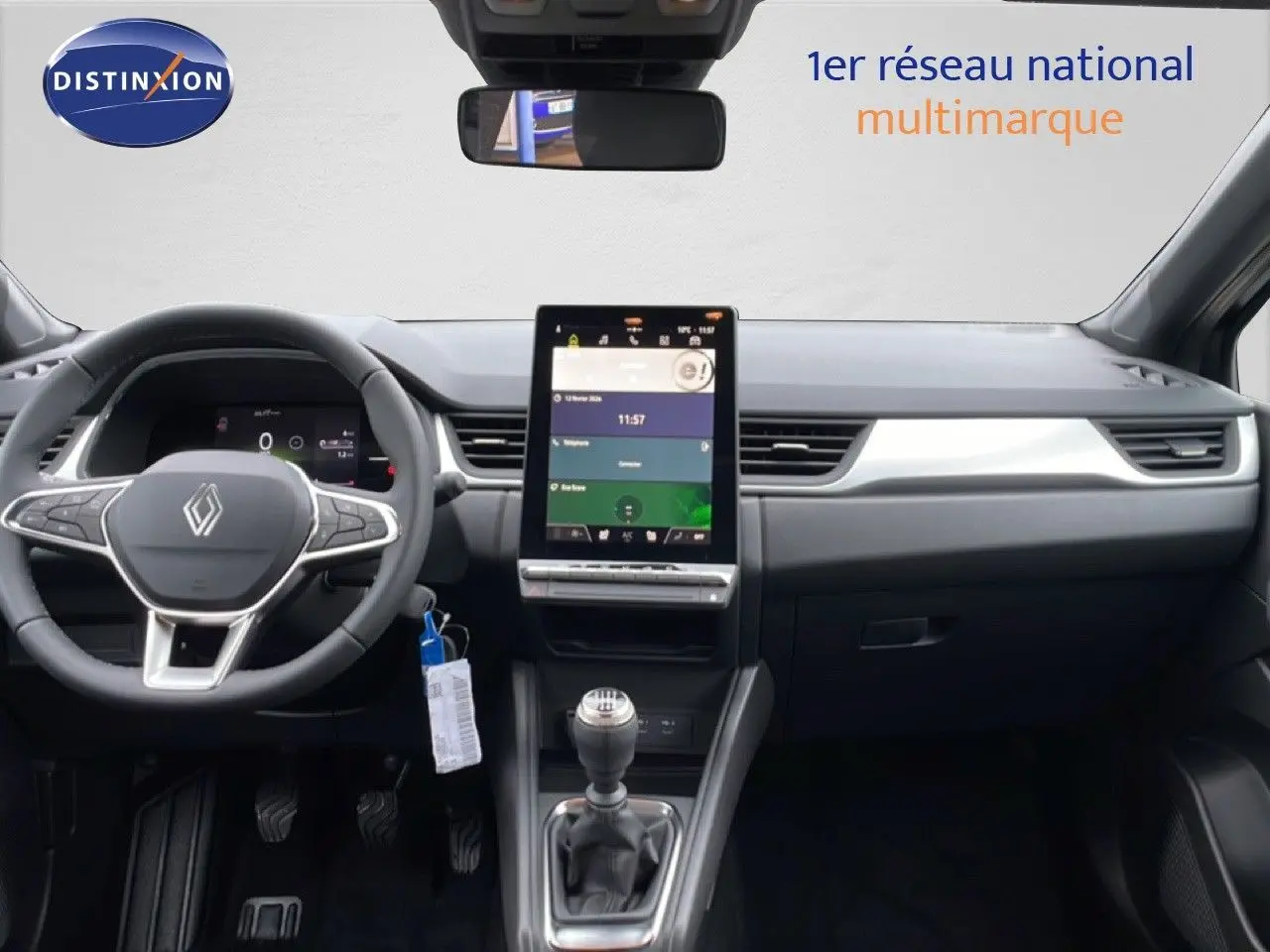 Vue intérieure frontale du tableau de bord du Renault Captur noir étoile métal 2025 avec écran tactile vertical et boîte manuelle.