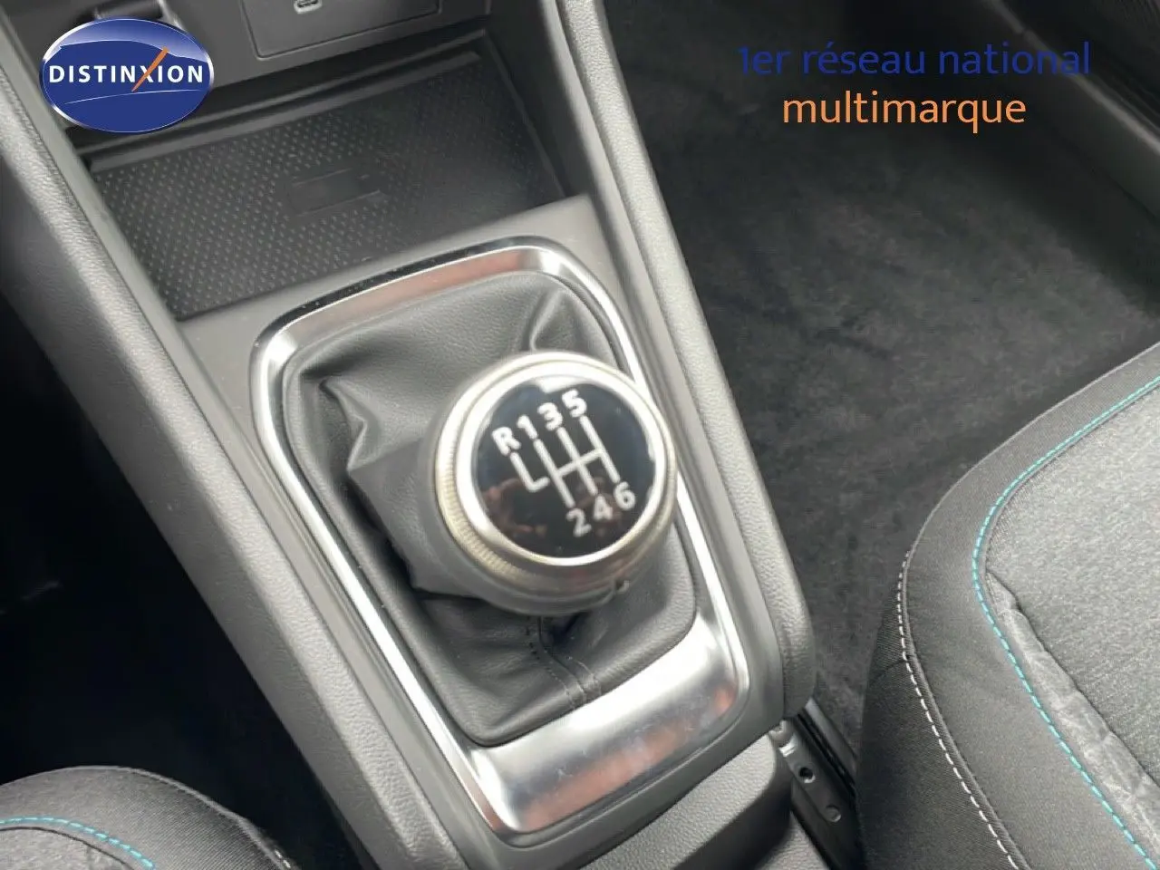 Gros plan sur le levier de vitesses manuel du Renault Captur 2025, intérieur noir avec surpiqûres bleues.