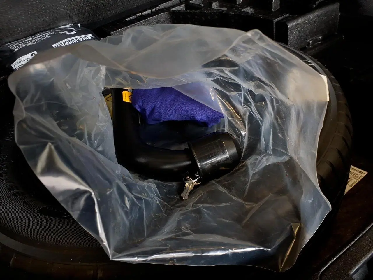 Gros plan sur le crochet d'attelage amovible du Ford Kuga 2024, emballé dans un sac plastique transparent.