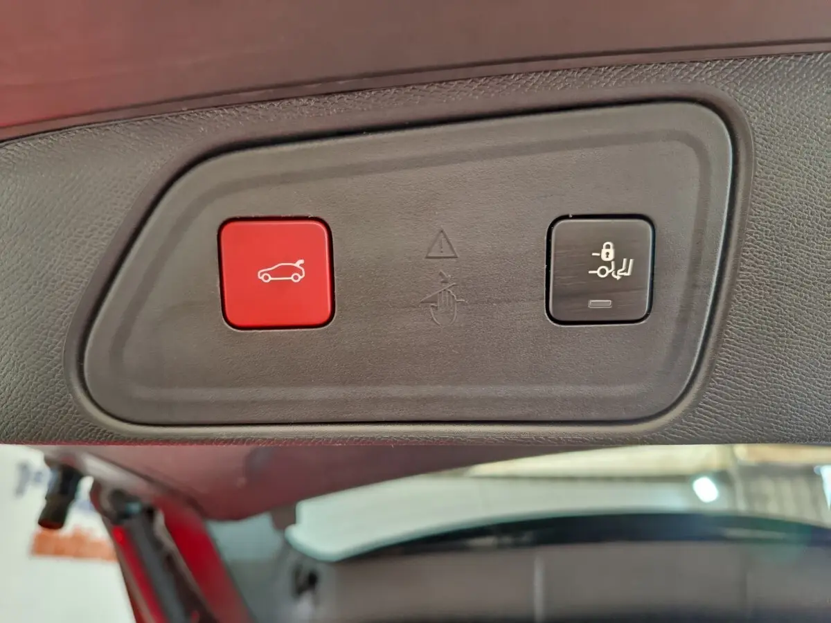 Gros plan sur les boutons d'ouverture et de verrouillage du coffre du Peugeot 3008 bleu, vue intérieure du hayon.