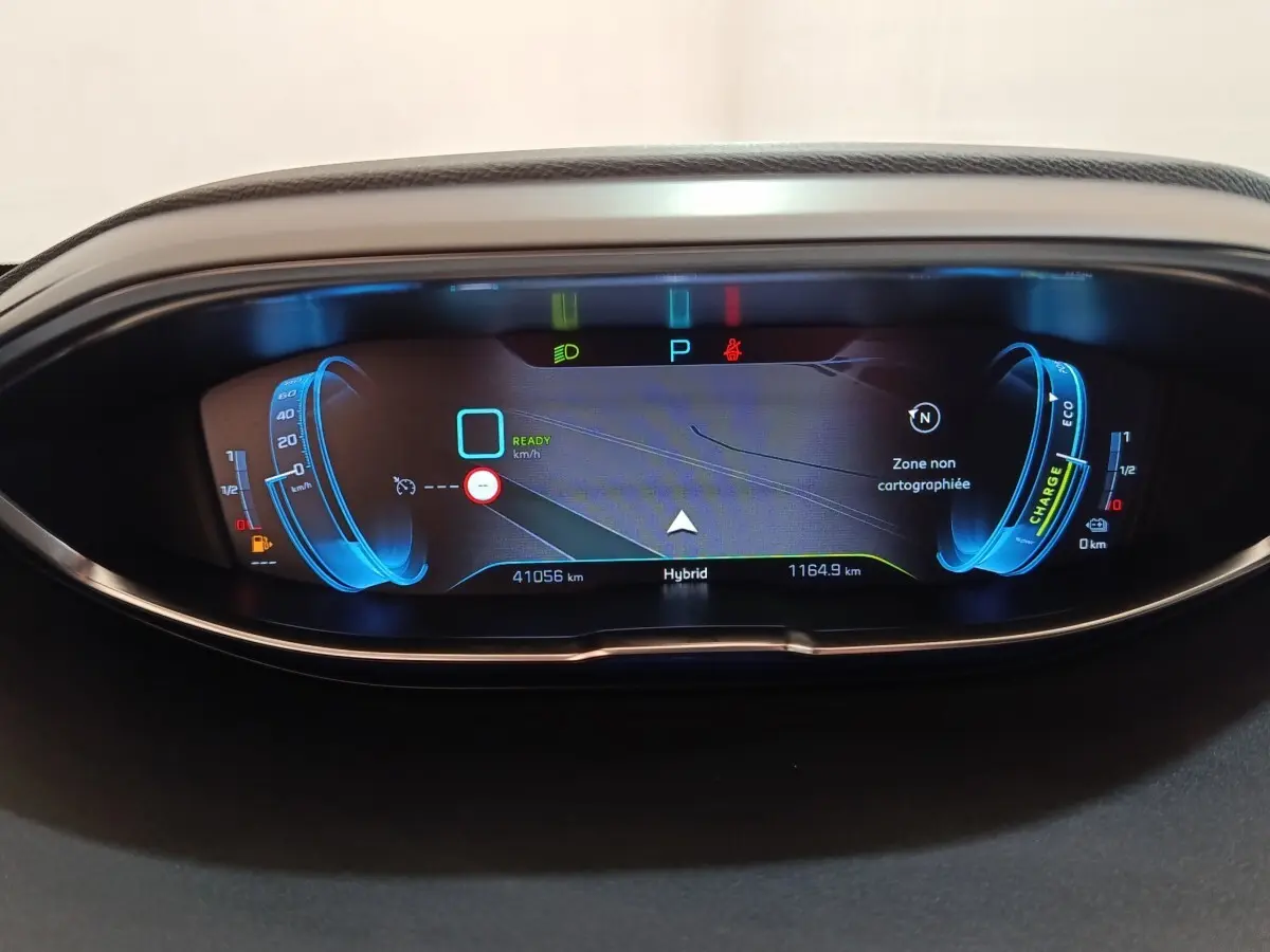 Vue rapprochée du tableau de bord numérique bleu du Peugeot 3008 Hybrid 225 GT Pack affichant la navigation et l'autonomie.