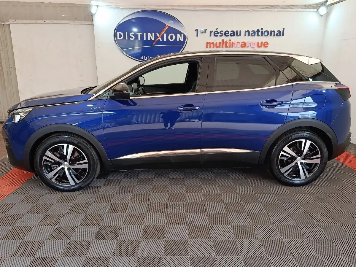 Vue de profil côté gauche d'un Peugeot 3008 bleu hybride rechargeable avec jantes alliage et toit noir.